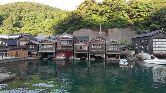 Aerial drone shot moving forward slowly towards the traditional Funaya boat houses in Ine, Kyoto, Japan