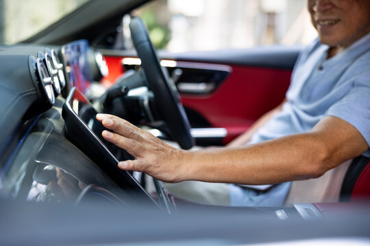 Man interacts with touchscreen in modern car interior.