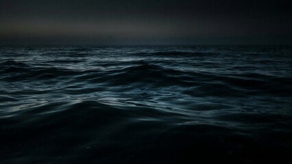 Fototapeta premium Dark and moody ocean waves gently rolling under a twilight sky at dusk