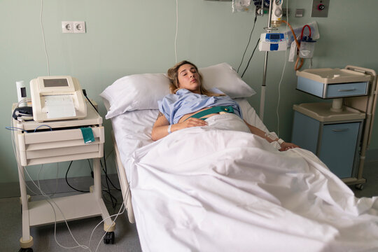 Pregnant woman receiving medical monitoring in hospital bed