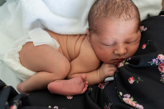 Newborn baby sleeping peacefully on mother's chest