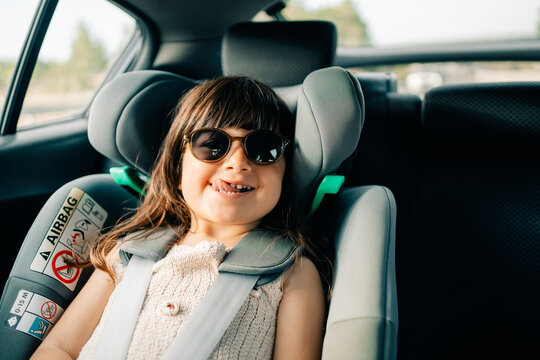 Child Enjoys Ride in Car Wearing Sunglasses on Sunny Day