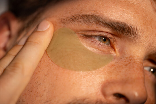 Man putting under eye patches
