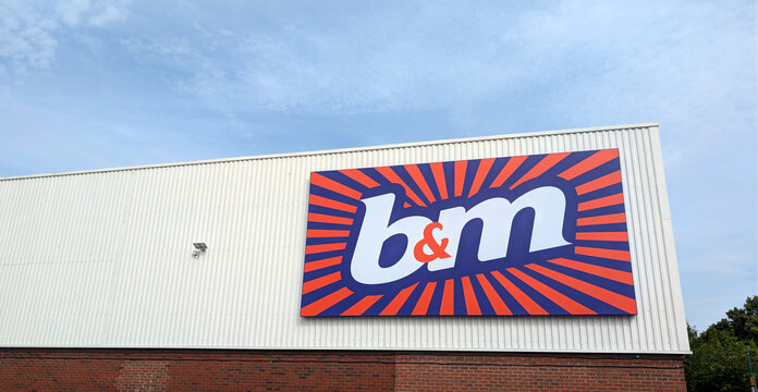 Leicester, England, UK - 20 June 2026: B&M store sign on building facade, brand logo on retail warehouse exterior, British discount supermarket storefront against blue sky