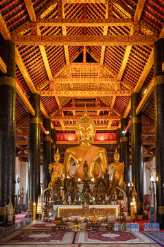 Golden Buddha statue inside a traditional Buddhist temple in Luang Prabang, Laos