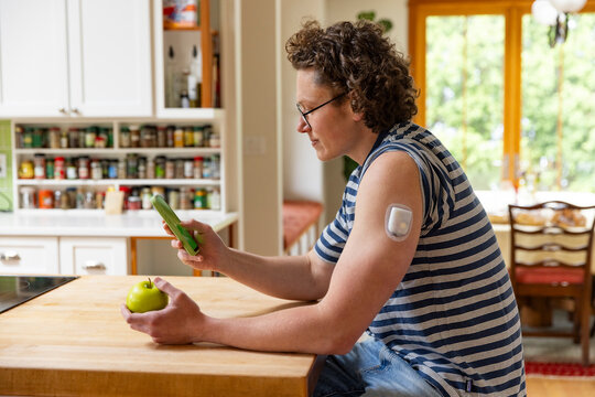Smartphone App continuous glucose monitor checking man 