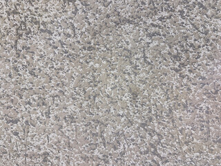 Close up of a roughcast wall featuring a speckled mix of grey and white paint, creating a highly tactile, industrial pebbledash surface texture. © TMR Studio