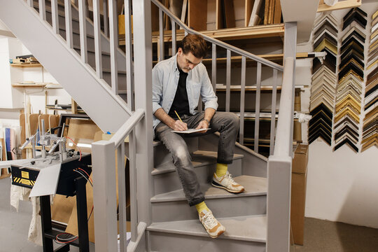 Artist sketching on stairs in art workshop