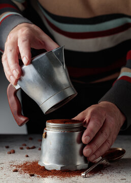 Man is prepared coffee in a classic Italian aluminium moka pot.