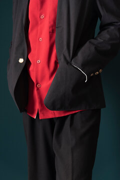 Fashion model putting hand into a black suit jacket