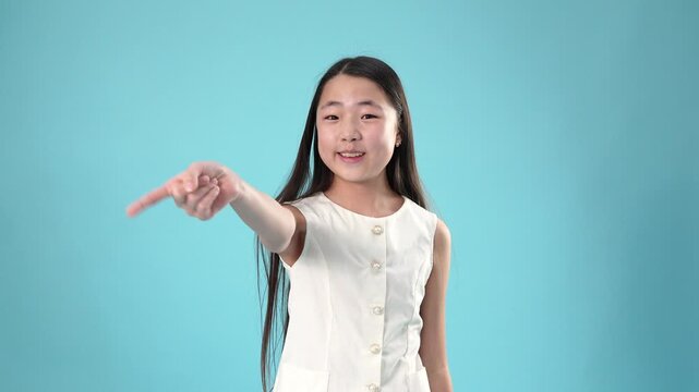 Confused asian girl shrugging shoulders and pointing at camera
