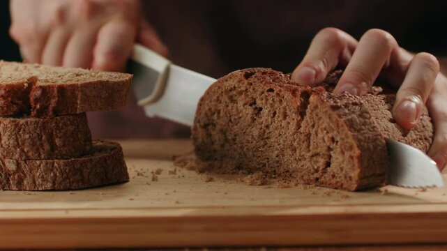 Black rye bread close up, cutting with knife dark brown sliced loaf, borodinsky slavic food, square slices with coriander on white background, baker with tasty healthy fresh bread.