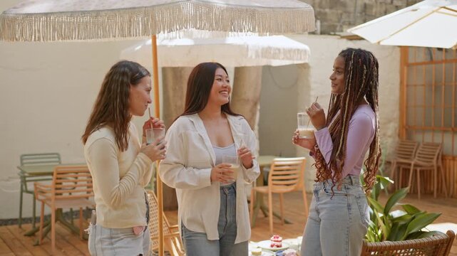 Diverse friends enjoying drinks at a cafe terrace