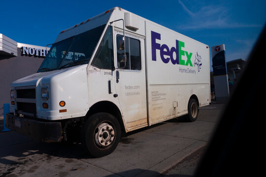 Large white FedEx delivery truck making a stop with rear doors open for easy package assessment. St Paul Minnesota MN USA