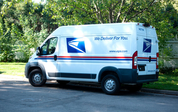 U. S. Mail delivery truck parked on a tree lined street delivering the mail. St Paul Minnesota MN USA