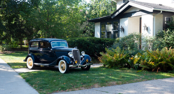 Vintage 1934 Ford Model 40 car displayed on front yard of a neighborhood home. Identified by Google, recheck before using. St Paul Minnesota MN USA