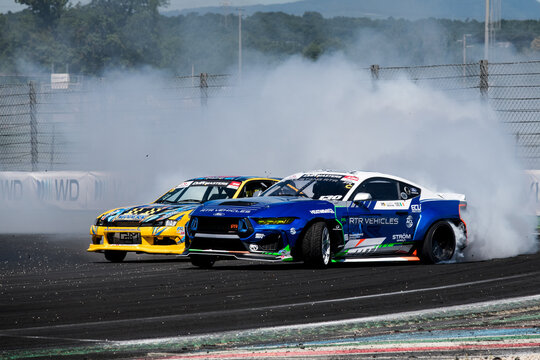 Two cars drift action challenge, drifting on racetrack with large amount of smoke