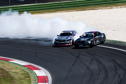Two cars drift action challenge, drifting on racetrack with large amount of smoke