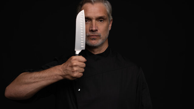 Portrait of positive 50s mature chef cook, black outfit