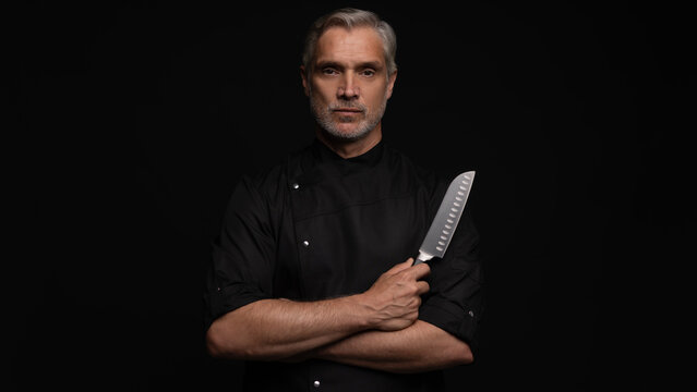 Portrait of positive 50s mature chef cook, black outfit