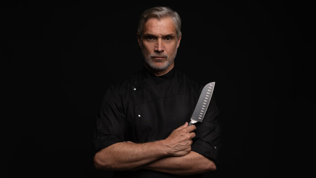 Portrait of positive 50s mature chef cook, black outfit