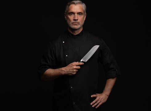 Portrait of positive 50s mature chef cook, black outfit