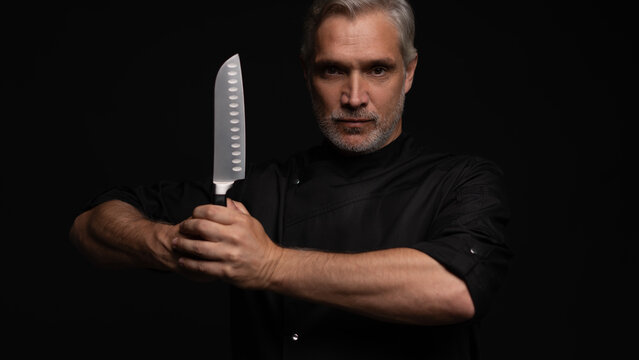 Portrait of positive 50s mature chef cook, black outfit