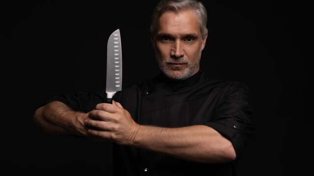 Portrait of positive 50s mature chef cook, black outfit