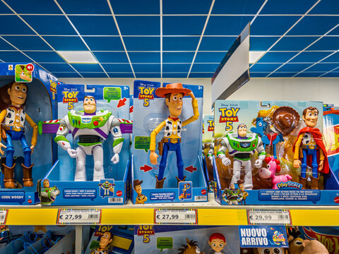 Italy - February 2026: Disney Pixar Toy Story 5 branded action figures by Mattel, including Buzz Lightyear and Woody, neatly arranged on a bright yellow supermarket display shelf with European price 