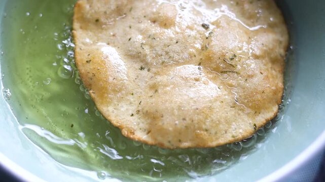 Indian bread or puri or pudi being fried in hot oil