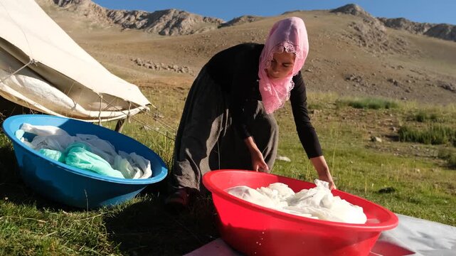 A woman works with basins, pots, and cloths during traditional cheese making in the highlands, showing handmade rural production, open-air preparation, and an authentic pastoral lifestyle.