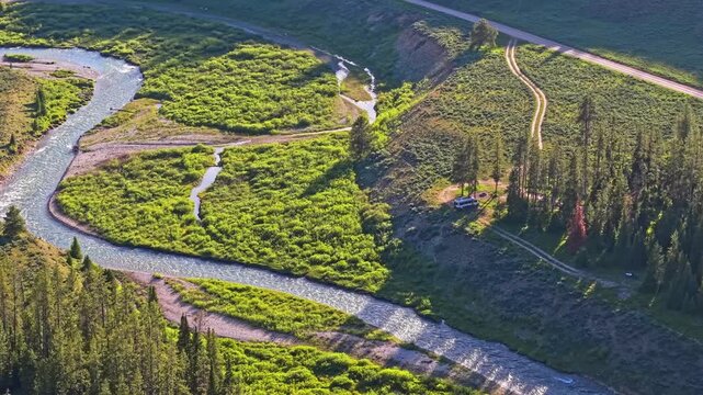Scenic aerial view shows Granite Creek winding through Wyoming with Teton Mountains beyond