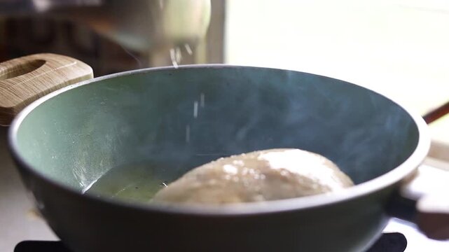 Indian bread or puri or pudi being fried in hot oil