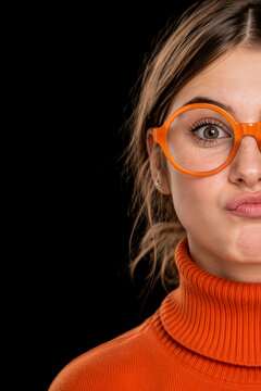Junge Frau mit oranger Brille und orangen Rollkragenpullover