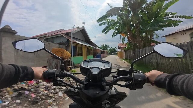POV Riding Motorcycle Through Rural Village