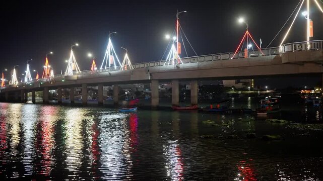 Nha Trang Vietnam. 01 06 2026 Nha Trang Vietnam. 01 06 2026 Night waterfront bridge with decorative LED pylons, curved streetlamps, concrete spans, calm river reflections, dark sky, urban