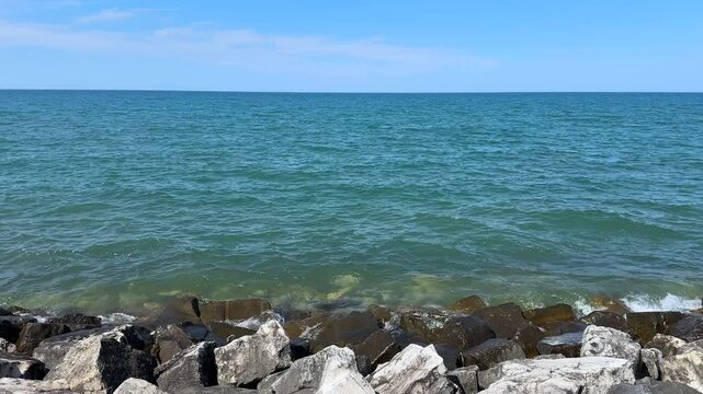 Rocky shoreline with calm blue waters of Lake Michigan against the horizon