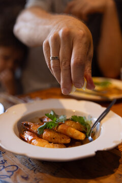Male hand squeezing fresh lemon onto plate of shrimp in Portugal. 
