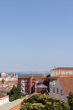 view of Lisbon city with architecture with Tagus River in the background, blue sky, sunny day
