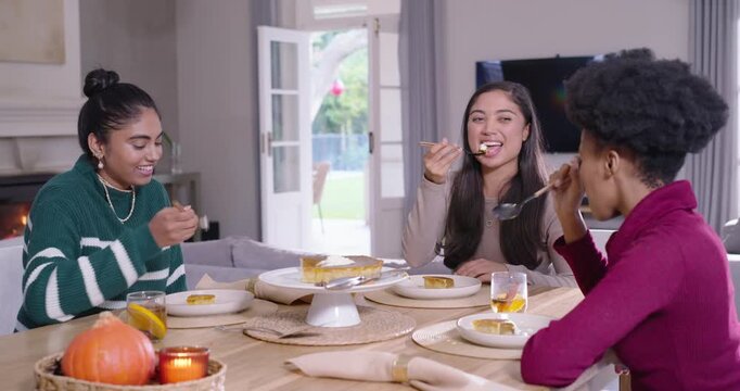 Female friends spotting sliced pie on cake stand, reaching, serving, sharing dessert at home