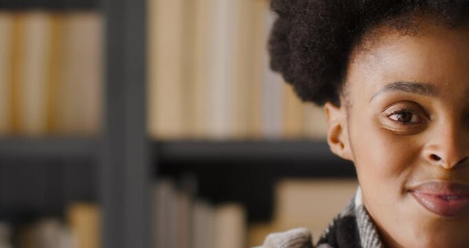 African American woman blinking opening eyes smiling as camera pulling in study scarf, copy space