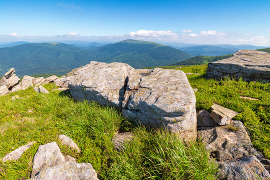 mountain landscape with grass and rock on a slope. view in to the distant valley of carpathian mountains. mountainous scenery of ukraine in summer. green environment concept for poster