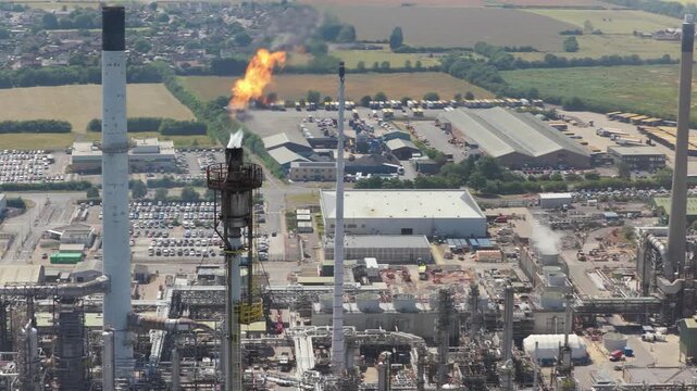Industrial Oil Refinery in England With a Tall Flare Stack Burning Gas