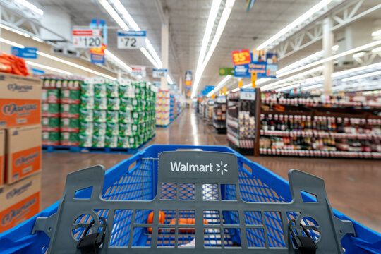 Blue shopping cart from a Walmart store, by Walmart Inc., located in the interior aisles of the supermarket surrounded by shelves with displayed merchandise. Jalisco, Mexico, July 20 2026