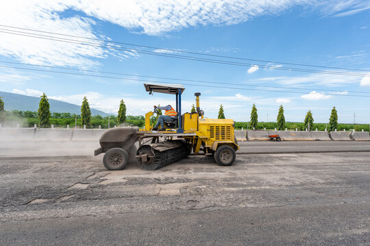 Yellow Superior Broom tow sweeper brushing asphalt before road repaving operations. Jalisco, Mexico, July 20, 2026.