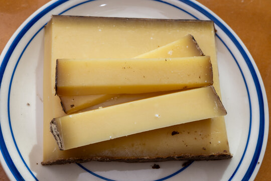 Comte hard french cheese from France's Jura Mountains made from unpasteurized cow's milk with traditional methods in cooperative dairies with nutty flavor, creamy texture, aged in natural caves