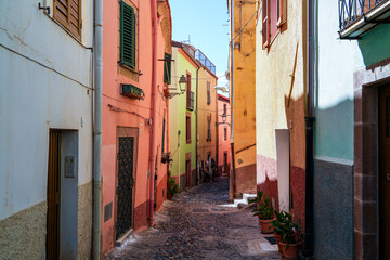 Fototapeta premium Narrow cobblestone street lined with colorful houses in the historic town of Bosa, Sardinia, Italy