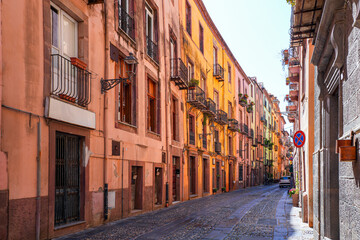 Fototapeta premium Street view of the cobbled Corso Vittorio Emanuele II in Bosa, Sardinia, Italy, with colorful historic architecture