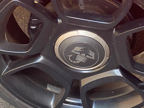 Abarth scorpion logo on a dark gray alloy wheel, showcasing brand identity and automotive style