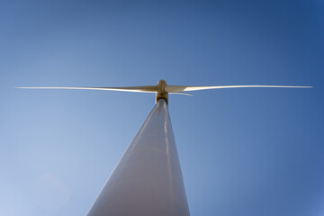 Fototapeta premium close up of one wind turbine in a windfarm seen from below, power plant for renewable electric energy source